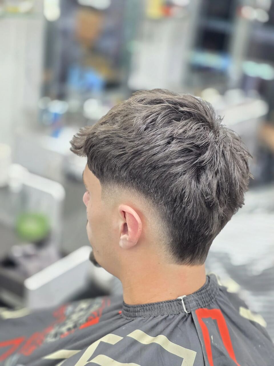 A skin fade with textured hair on top